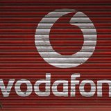 A woman walks past a large logo of Vodafone displayed on a shop in Mumbai May 20, 2010. REUTERS/Arko Datta A woman walks past a large logo of Vodafone displayed on a shop in Mumbai May 20, 2010. REUTERS/Arko Datta