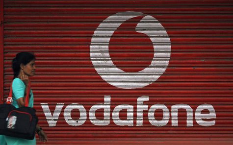 A woman walks past a large logo of Vodafone displayed on a shop in Mumbai May 20, 2010. REUTERS/Arko Datta A woman walks past a large logo of Vodafone displayed on a shop in Mumbai May 20, 2010. REUTERS/Arko Datta