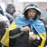A protester holds a piece of bread as he gathers with others at Independence Square during a rally to support EU integration in Kiev Decembe A protester holds a piece of bread as he gathers with others at Independence Square during a rally to support EU integration in Kiev Decembe