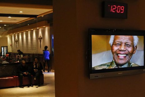 Nelson Mandela is pictured on a display screen as people attend a tribute service for him at the Christian Cultural Center in the Brooklyn a Nelson Mandela is pictured on a display screen as people attend a tribute service for him at the Christian Cultural Center in the Brooklyn a