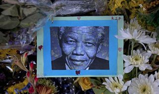 A photograph of the late South African President Nelson Mandela is surrounded by flowers during a tribute event held in his remembrance in front of the Town Hall in Cape Town December 8, 2013.
Credit: Reuters/Mark Wessels A photograph of the late South African President Nelson Mandela is surrounded by flowers during a tribute event held in his remembrance in front of the Town Hall in Cape Town December 8, 2013.
Credit: Reuters/Mark Wessels