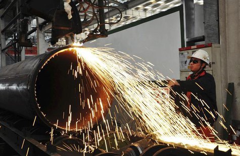 A worker operates a machine to cut a pipeline at a factory in Qingdao, Shandong province November 29, 2013. REUTERS/China Daily A worker operates a machine to cut a pipeline at a factory in Qingdao, Shandong province November 29, 2013. REUTERS/China Daily
