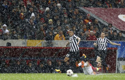 Arturo Vidal of Juventus (L) runs for the ball past Selcuk Inan of Galatasaray (bottom) during their Champions League soccer match in Istanb Arturo Vidal of Juventus (L) runs for the ball past Selcuk Inan of Galatasaray (bottom) during their Champions League soccer match in Istanb
