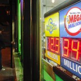 A customer arrives at a store where a Mega Millions sign is seen after the lottery grand prize rose to $344 million in New York December 7, A customer arrives at a store where a Mega Millions sign is seen after the lottery grand prize rose to $344 million in New York December 7,