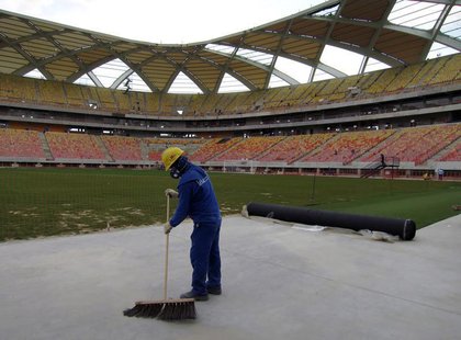 A workman next to the pitch inside the Arena Amazonia stadium as work continues in preparation for the 2014 FIFA World Cup soccer championsh A workman next to the pitch inside the Arena Amazonia stadium as work continues in preparation for the 2014 FIFA World Cup soccer championsh
