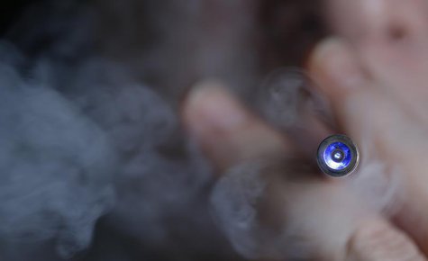 A man uses an E-cigarette, an electronic substitute in the form of a rod, slightly longer than a normal cigarette, in this illustration pict A man uses an E-cigarette, an electronic substitute in the form of a rod, slightly longer than a normal cigarette, in this illustration pict