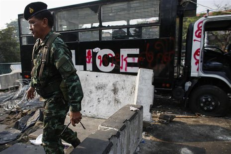 A soldier walk past a destroyed police truck near Government House, where anti-government protesters are gathered, in Bangkok December 11, 2 A soldier walk past a destroyed police truck near Government House, where anti-government protesters are gathered, in Bangkok December 11, 2
