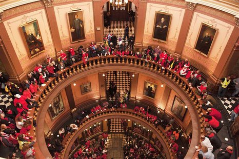 Labor union members and supporters hang a flag in the Capitol rotunda as they demonstrate in opposition to a proposed right-to-work measure Labor union members and supporters hang a flag in the Capitol rotunda as they demonstrate in opposition to a proposed right-to-work measure