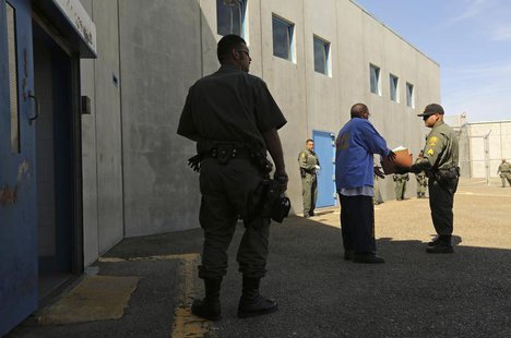 An inmate (C) is checked by guards after leaving a general population cell block, in Corcoran State Prison, California October 1, 2013. REUT An inmate (C) is checked by guards after leaving a general population cell block, in Corcoran State Prison, California October 1, 2013. REUT