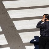 A man talks on his mobile phone as he waits at a crosswalk at Lindbergh Field Airport in San Diego, California, November 6, 2013. REUTERS/Mi A man talks on his mobile phone as he waits at a crosswalk at Lindbergh Field Airport in San Diego, California, November 6, 2013. REUTERS/Mi
