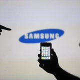 Men are silhouetted against a video screen with an Samsung logo as they pose with an Apple iPhone 4 smartphone in this photo illustration ta Men are silhouetted against a video screen with an Samsung logo as they pose with an Apple iPhone 4 smartphone in this photo illustration ta