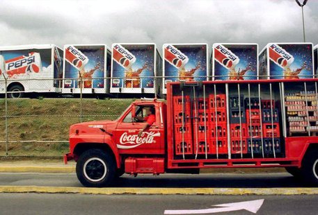 A Coca Cola truck passes in front of a Pepsi Co. parking lot filled with new Pepsi Cola trucks December 9. A Coca Cola truck passes in front of a Pepsi Co. parking lot filled with new Pepsi Cola trucks December 9.