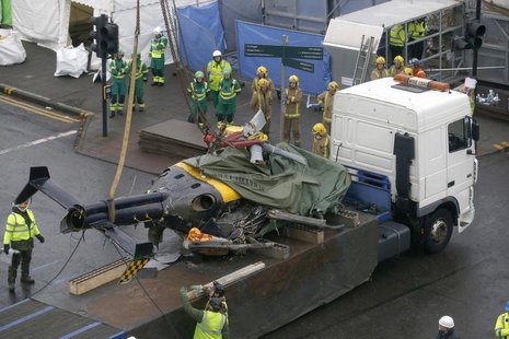 Rescue workers lift the wreckage of a police helicopter on to a trailer in central Glasgow, Scotland December 2, 2013. REUTERS/Russell Cheyn Rescue workers lift the wreckage of a police helicopter on to a trailer in central Glasgow, Scotland December 2, 2013. REUTERS/Russell Cheyn