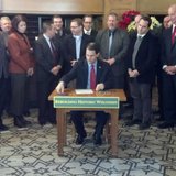 Governor Scott Walker signs the bill increasing Wisconsin's historic building restoration tax credit into law at the Hotel Northland in Green Bay on Dec. 11, 2013. (Photo by: WTAQ Reporter Jeff Flynt). Governor Scott Walker signs the bill increasing Wisconsin's historic building restoration tax credit into law at the Hotel Northland in Green Bay on Dec. 11, 2013. (Photo by: WTAQ Reporter Jeff Flynt).
