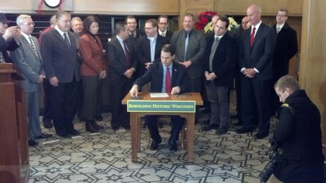 Governor Scott Walker signs the bill increasing Wisconsin's historic building restoration tax credit into law at the Hotel Northland in Green Bay on Dec. 11, 2013. (Photo by: WTAQ Reporter Jeff Flynt). Governor Scott Walker signs the bill increasing Wisconsin's historic building restoration tax credit into law at the Hotel Northland in Green Bay on Dec. 11, 2013. (Photo by: WTAQ Reporter Jeff Flynt).