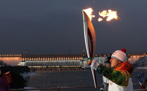 A runner carries the Sochi 2014 Winter Olympic torch along a bridge across Yenisei River near the Krasnoyarsk hydro electric power station n A runner carries the Sochi 2014 Winter Olympic torch along a bridge across Yenisei River near the Krasnoyarsk hydro electric power station n