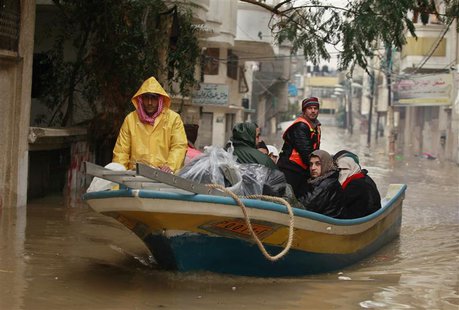 Members of Palestinian civil defense operate a boat as they evacuate people after their houses were flooded with rainwater on a stormy day i Members of Palestinian civil defense operate a boat as they evacuate people after their houses were flooded with rainwater on a stormy day i