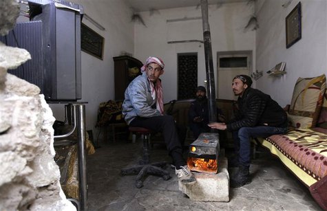 Free Syrian Army fighters warm themselves around a heater inside a room in Deir al-Zor, eastern Syria, December 12, 2013. REUTERS/Khalil Ash Free Syrian Army fighters warm themselves around a heater inside a room in Deir al-Zor, eastern Syria, December 12, 2013. REUTERS/Khalil Ash