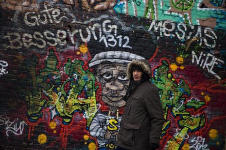 Dimitar "Mitko" Todorov, a Roma from the Bulgarian city of Plevna, walks past a graffiti at a former ice factory that serves as his home in Dimitar "Mitko" Todorov, a Roma from the Bulgarian city of Plevna, walks past a graffiti at a former ice factory that serves as his home in