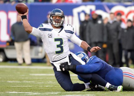 Dec 15, 2013; East Rutherford, NJ, USA; Seattle Seahawks quarterback Russell Wilson (3) throws a pass as he is taken down by New York Giants Dec 15, 2013; East Rutherford, NJ, USA; Seattle Seahawks quarterback Russell Wilson (3) throws a pass as he is taken down by New York Giants