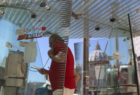 A man uses a Telecom Italia phone booth in front of St Peter's Basilica in Rome September 24, 2013. REUTERS/Alessandro Bianchi A man uses a Telecom Italia phone booth in front of St Peter's Basilica in Rome September 24, 2013. REUTERS/Alessandro Bianchi