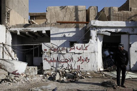 A man stands at the scene of a car bomb attack in the Risala district in Baghdad December 15, 2013. REUTERS/Thaier Al-Sudani A man stands at the scene of a car bomb attack in the Risala district in Baghdad December 15, 2013. REUTERS/Thaier Al-Sudani