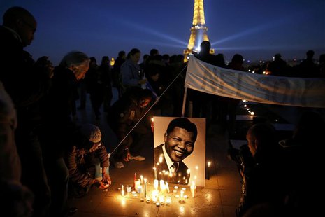 People place candles near a photo as they pay tribute to former South African President Nelson Mandela at the Trocadero square, in front of People place candles near a photo as they pay tribute to former South African President Nelson Mandela at the Trocadero square, in front of