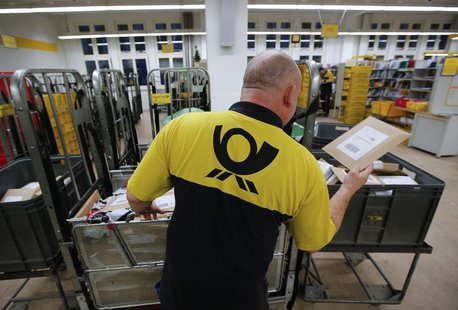 A postman of the German postal and logistics group Deutsche Post sorts mail at a sorting office in Berlin's Mitte district, December 4, 2013 A postman of the German postal and logistics group Deutsche Post sorts mail at a sorting office in Berlin's Mitte district, December 4, 2013