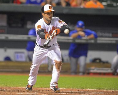 Baltimore Orioles batter Brian Roberts lays down a bunt to Toronto Blue Jays third baseman Brett Lawrie during the third inning of their MLB Baltimore Orioles batter Brian Roberts lays down a bunt to Toronto Blue Jays third baseman Brett Lawrie during the third inning of their MLB
