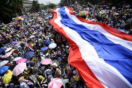 Anti-government protesters unveil a large Thai flag as they descend on Government House in Bangkok December 9, 2013. REUTERS/Dylan Martinez Anti-government protesters unveil a large Thai flag as they descend on Government House in Bangkok December 9, 2013. REUTERS/Dylan Martinez