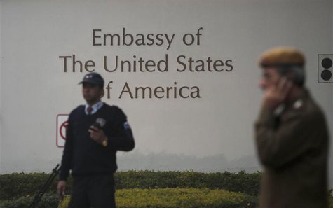 A U.S. embassy security guard (L) and an Indian policeman stand in front of the main gate of the embassy as the bulldozer (unseen) removes t A U.S. embassy security guard (L) and an Indian policeman stand in front of the main gate of the embassy as the bulldozer (unseen) removes t