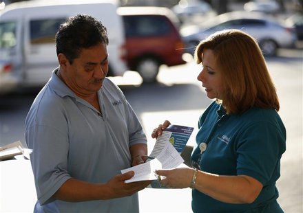 Engrith Acosta, patient care coordinator at AltaMed, speaks to a man during a community outreach on Obamacare in Los Angeles, California Nov Engrith Acosta, patient care coordinator at AltaMed, speaks to a man during a community outreach on Obamacare in Los Angeles, California Nov