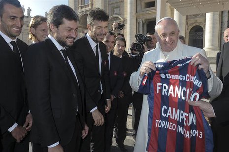 Pope Francis holds a jersey of Argentine soccer team San Lorenzo, given to him as a gift from members of the team, during the Wednesday gene Pope Francis holds a jersey of Argentine soccer team San Lorenzo, given to him as a gift from members of the team, during the Wednesday gene
