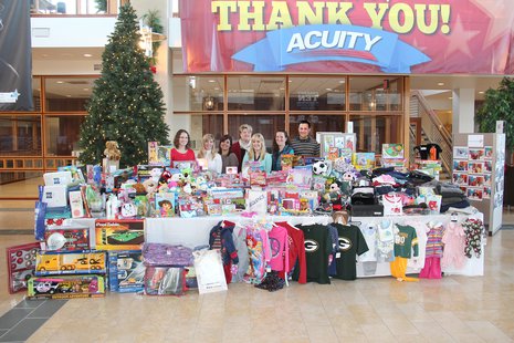 ACUITY employees stand by some of the donations made to this year's holiday gift drive. ACUITY employees stand by some of the donations made to this year's holiday gift drive.