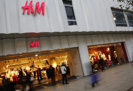 People walk past the window of an H&M textile shop in this longtime exposure photograph taken in Frankfurt December 4, 2013. REUTERS/Kai Pfa People walk past the window of an H&M textile shop in this longtime exposure photograph taken in Frankfurt December 4, 2013. REUTERS/Kai Pfa