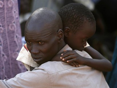 An internally displaced man holds his son inside a United Nations Missions in Sudan (UNMIS) compound in Juba December 19, 2013. REUTERS/Gora An internally displaced man holds his son inside a United Nations Missions in Sudan (UNMIS) compound in Juba December 19, 2013. REUTERS/Gora