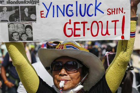 An anti-government protester holds a placard as she gathers with others during a rally at a major business district in Bangkok December 19, An anti-government protester holds a placard as she gathers with others during a rally at a major business district in Bangkok December 19,