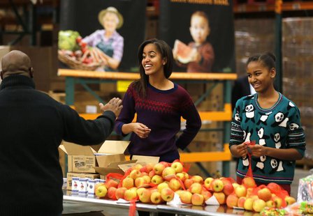 Malia (L) and Sasha (R), daughters of U.S. President Barack Obama and first lady Michelle Obama hand out Thanksgiving food at the Capital Ar Malia (L) and Sasha (R), daughters of U.S. President Barack Obama and first lady Michelle Obama hand out Thanksgiving food at the Capital Ar