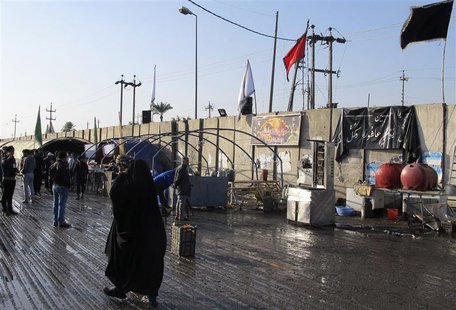A woman walks near the site of a bomb attack in Baghdad's Doura District, December 19, 2013. REUTERS/Ahmed Malik A woman walks near the site of a bomb attack in Baghdad's Doura District, December 19, 2013. REUTERS/Ahmed Malik