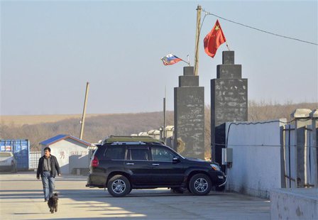 A man walks past the gates of the "Armada" farming project run by Dongning Huaxin Group near the far eastern Russian town of Ussuriysk Novem A man walks past the gates of the "Armada" farming project run by Dongning Huaxin Group near the far eastern Russian town of Ussuriysk Novem