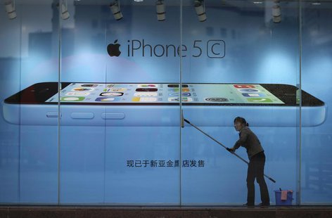 A worker cleans glass in front of an iPhone 5C advertisement at an apple store in Kunming, Yunnan province, in this October 27, 2013 file pi A worker cleans glass in front of an iPhone 5C advertisement at an apple store in Kunming, Yunnan province, in this October 27, 2013 file pi