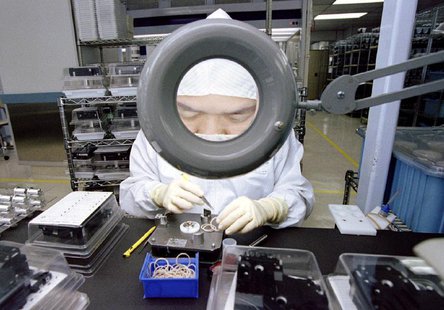 An employee of Seagate Technology is enlarged by a magnifying glass as she concentrates on assembling hard disk drives in a "clean room" at An employee of Seagate Technology is enlarged by a magnifying glass as she concentrates on assembling hard disk drives in a "clean room" at