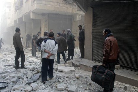 People stand on the rubble of damaged buildings after what activists said was an air raid by forces loyal to Syrian President Bashar Al-Assa People stand on the rubble of damaged buildings after what activists said was an air raid by forces loyal to Syrian President Bashar Al-Assa