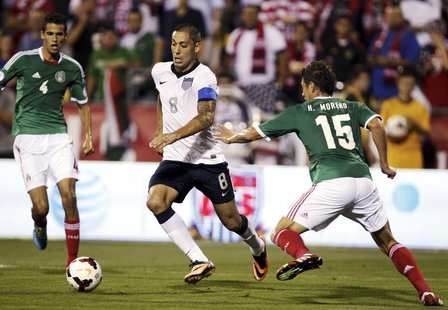 United States' midfielder Clint Dempsey (8) takes the ball past Mexico's Diego Reyes (4) and Hector Moreno (15) during the first half of the United States' midfielder Clint Dempsey (8) takes the ball past Mexico's Diego Reyes (4) and Hector Moreno (15) during the first half of the