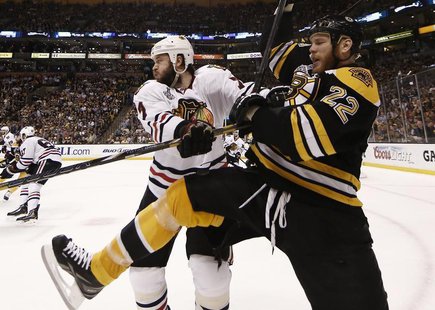 Boston Bruins right wing Shawn Thornton (22) is hit into the boards by Chicago Blackhawks defenseman Brent Seabrook (7) in Game 3 of their N Boston Bruins right wing Shawn Thornton (22) is hit into the boards by Chicago Blackhawks defenseman Brent Seabrook (7) in Game 3 of their N