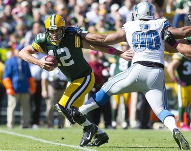 Green Bay Packers quarterback Aaron Rodgers (12) runs with the ball in front of Detroit Lions defensive tackle Ndamukong Suh (90) during the Green Bay Packers quarterback Aaron Rodgers (12) runs with the ball in front of Detroit Lions defensive tackle Ndamukong Suh (90) during the