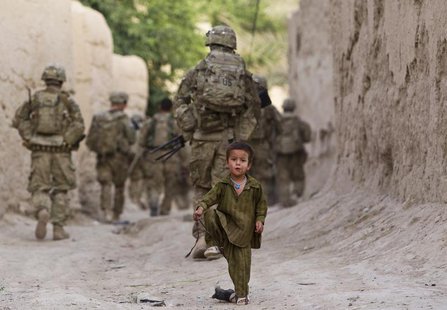A boy plays on a street as U.S. Army soldiers of the Battle company, 1-508 Parachute Infantry battalion, 4th Brigade Combat Team, 82nd Airbo A boy plays on a street as U.S. Army soldiers of the Battle company, 1-508 Parachute Infantry battalion, 4th Brigade Combat Team, 82nd Airbo
