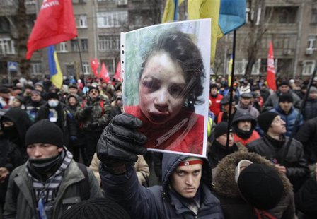 A protester holds a picture of journalist Tetyana Chornovil, who was beaten and left in a ditch just hours after publishing an article on th A protester holds a picture of journalist Tetyana Chornovil, who was beaten and left in a ditch just hours after publishing an article on th