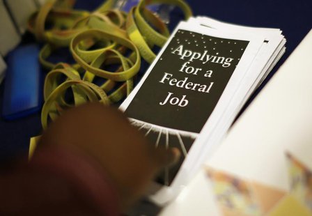 A man picks up a leaflet at a job fair in Los Angeles, California, November 18, 2013. REUTERS/Lucy Nicholson A man picks up a leaflet at a job fair in Los Angeles, California, November 18, 2013. REUTERS/Lucy Nicholson