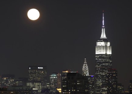 The moon rises behind the skyline of New York and the Empire State Building (R), as seen from Jersey City, New Jersey, December 18, 2013. RE The moon rises behind the skyline of New York and the Empire State Building (R), as seen from Jersey City, New Jersey, December 18, 2013. RE